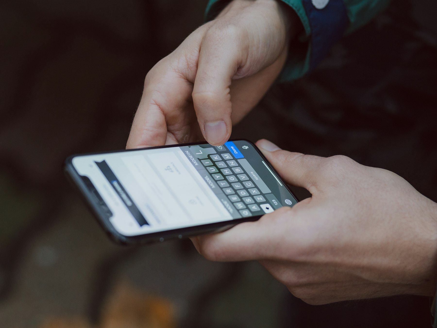Hands typing a message on a smartphone